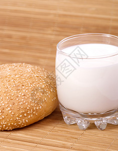 木桌上的小圆面包和一杯牛奶图片