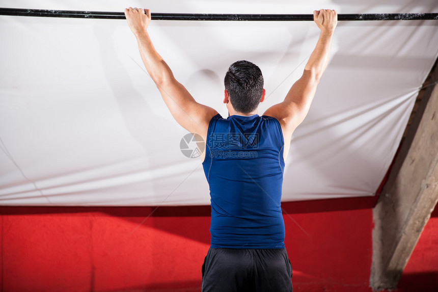 运动健壮的年轻男子准备在交叉训练体育馆拉图片