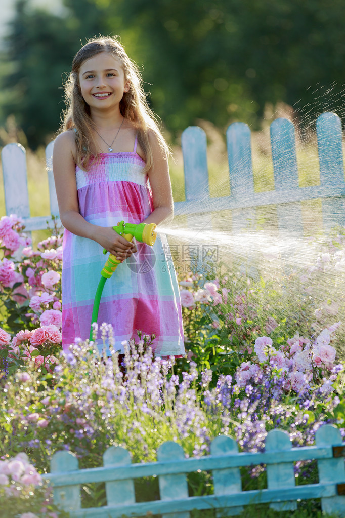 浇水花卉园浇水玫瑰的美丽女孩图片