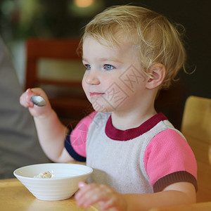 快乐的小孩金发小金发女孩吃咖啡馆碗里图片