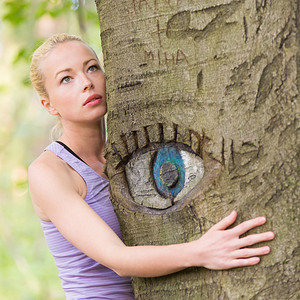 从大自然获得生命能量的树上放松的年轻女士坐在树图片