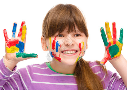 一个可爱的快乐女孩的肖像展示她的双手画着明亮的颜色孤图片
