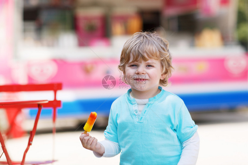 快乐的小孩男孩在夏天吃多彩的冰图片