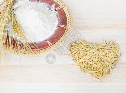 金粒小麦在木桌上用面粉盘子上的图片