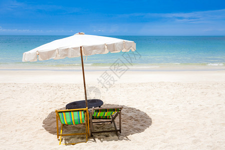 白色沙滩上的沙滩椅蓝天多云图片
