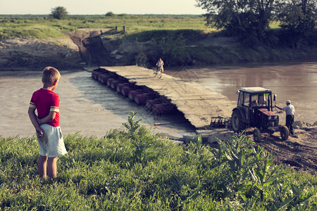 儿童用背景拖拉机观看河图片