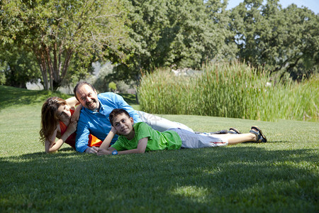 幸福的家庭躺在公园的草图片