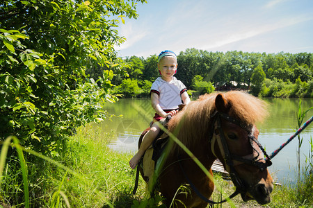 男孩骑着小马在大自然中图片