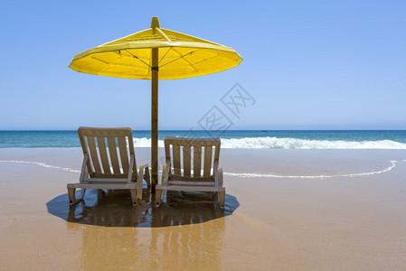 空转带雨伞的沙椅和美丽的沙滩在阳背景