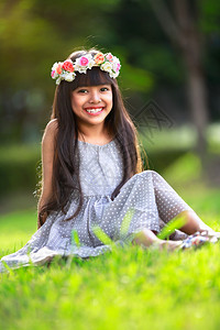 可爱的小女孩坐在公园的草地上户外肖像图片
