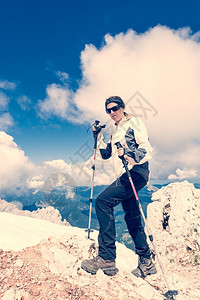 年轻女孩爬上山顶背面有登山的柱图片