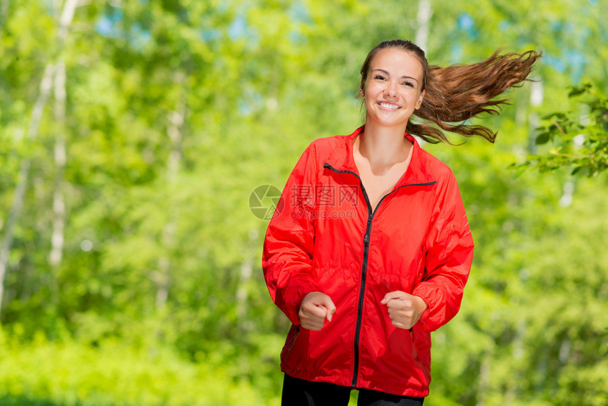 年轻健康的女运动员在夏季公园中跑步图片