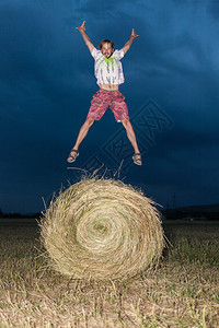 男人在干草场上跳跃图片