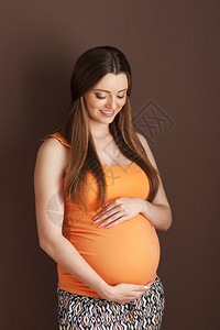 拥抱腹部的可爱的孕妇图片