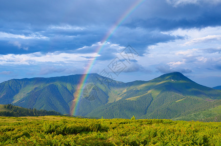 山上有彩虹的夏季风景雨后阳光图片