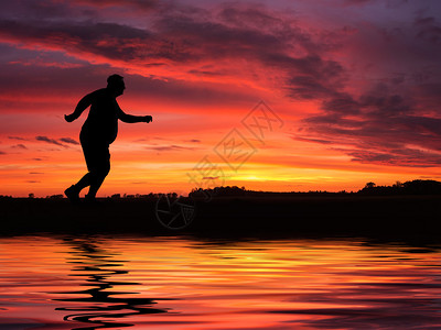有趣的超重男子在湖边慢跑的剪影图片