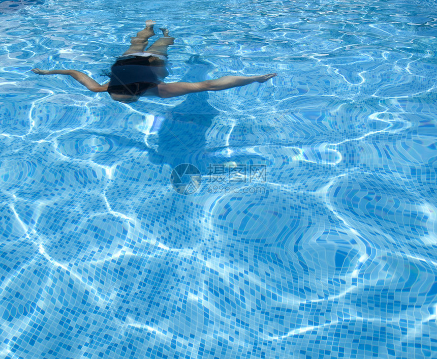 穿泳衣在蓝水池游泳的女图片