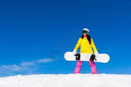 单板滑雪者站立举雪板雪山坡图片