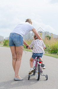 女人教小女孩骑单车图片