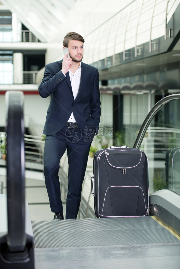 青年商人在机场携带手提箱和机票旅行图片