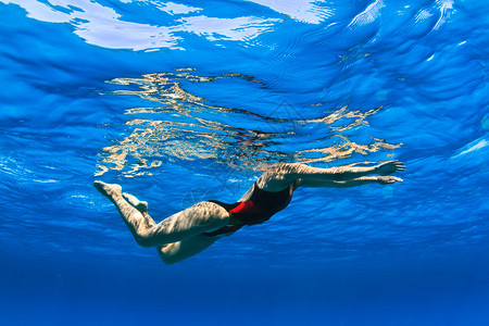 女专业游泳运动员在蓝色红海水中图片