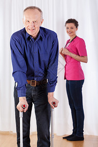 物理治疗师和老人拄着拐杖走路图片