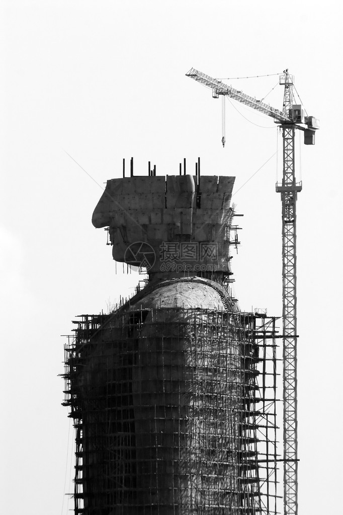 起重机在大佛雕塑泰国的高层建筑图片