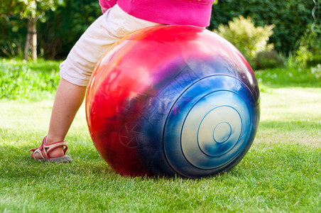 小女孩在花园里跳球背景