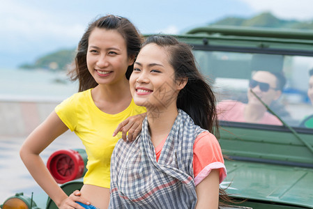 两个快乐的越南女孩站在越野车前图片