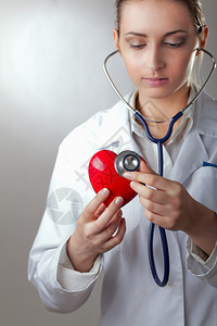 一名医生有听诊器检查红心孤立图片