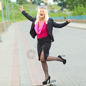 在户外玩滑板的高级商界女强人图片