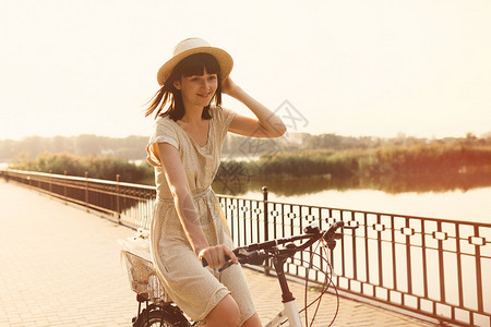 女孩在湖边公园里骑自行车闪光效应图片
