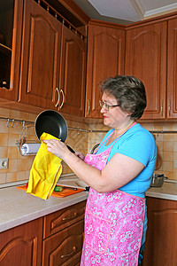 女主妇在厨房擦锅图片