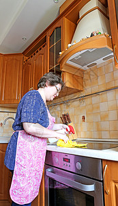 女家庭主妇在厨房清洁炉灶图片