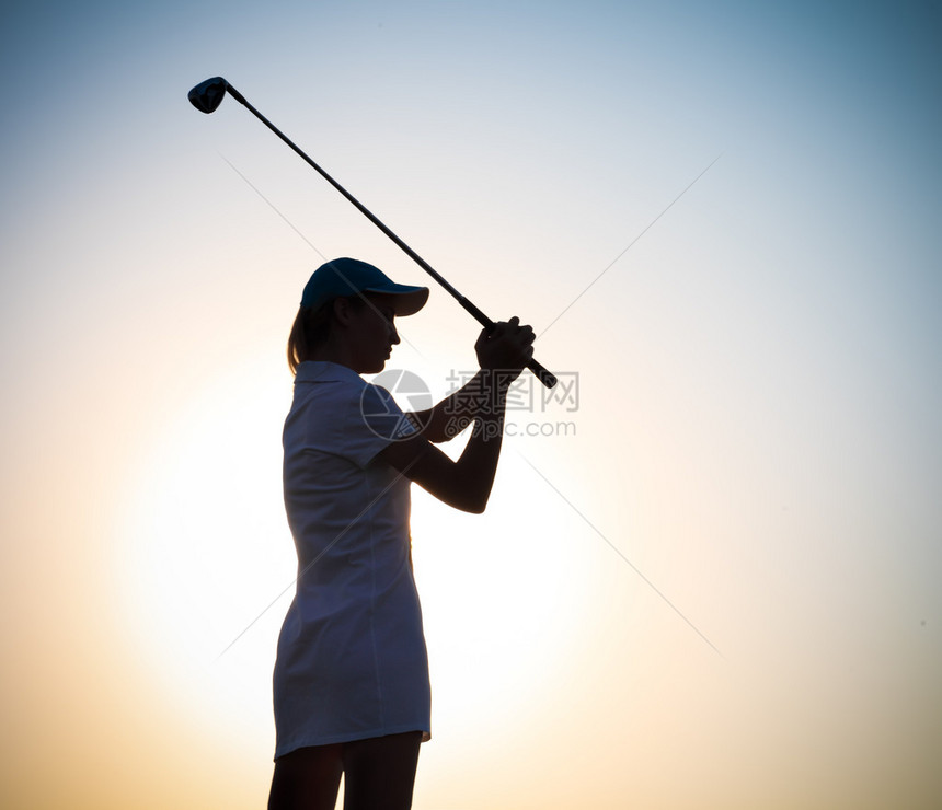 日落时打高尔夫球的女高尔夫球手图片