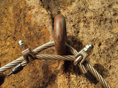 铁制扭曲的绳子被螺丝钉钩固定在一块儿上图片