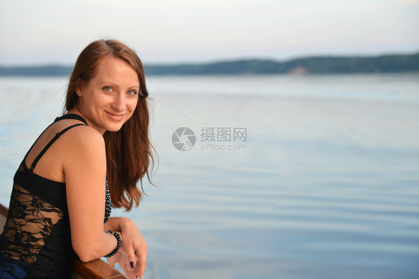 站在游轮甲板上的年轻女子图片