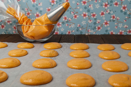 准备烘烤一批橙色杏仁饼的生面团图片