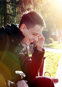 在秋天公园用手机拍摄的快乐的年轻人的照片图片