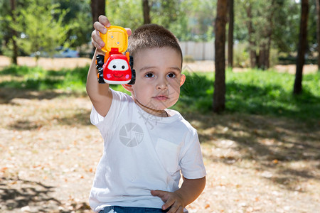 可爱的小孩男夏天在公园里玩具车图片
