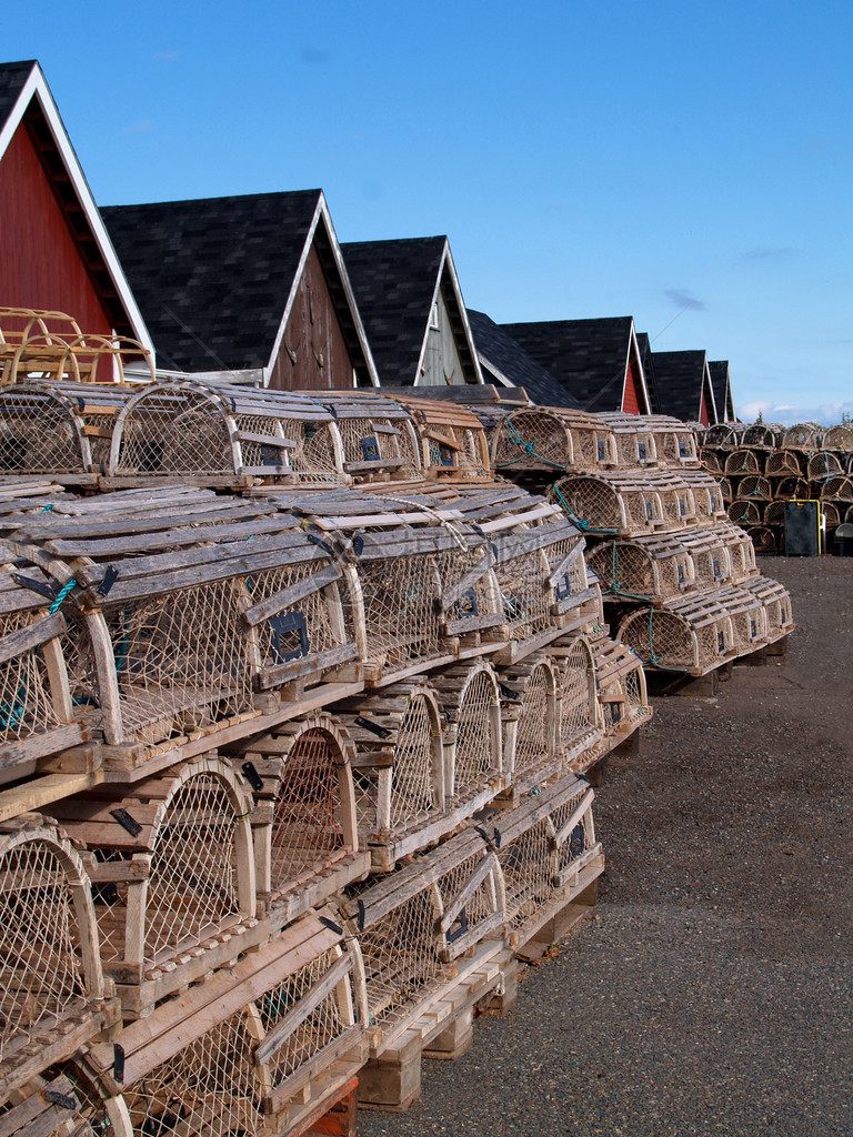 龙虾陷阱堆放在渔棚旁边的码头上图片