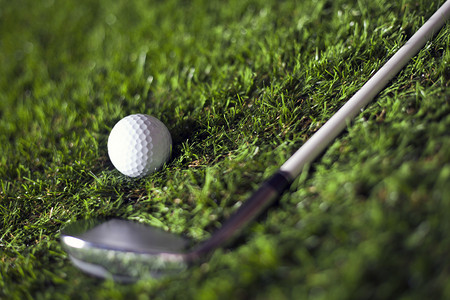 高尔夫球杆和绿草上的球图片