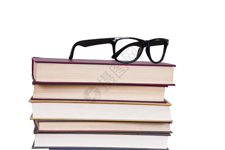 堆叠的书籍业务和物品上方的眼镜图片