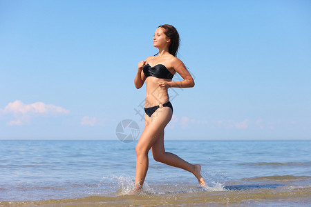 年轻女子在水中奔跑图片