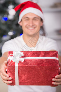 圣诞时带礼物的快乐年轻男子的肖像图片