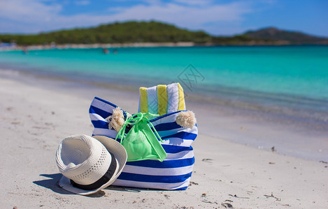 白沙热带海滩上的沙袋草帽图片