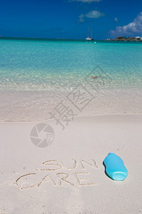 写在热带白色沙滩上的防晒霜背景图片