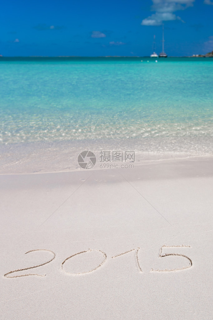 圣诞快乐写在热带沙滩上的白沙子上图片