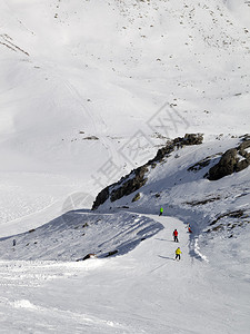 单板滑雪者和滑雪者在阳光日的滑雪坡上图片