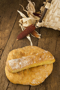 旧木背景上的玉米面包和玉米棒子图片
